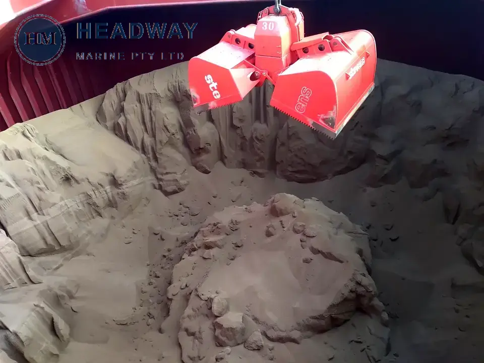 Bulk fertiliser being handled by a ship grab